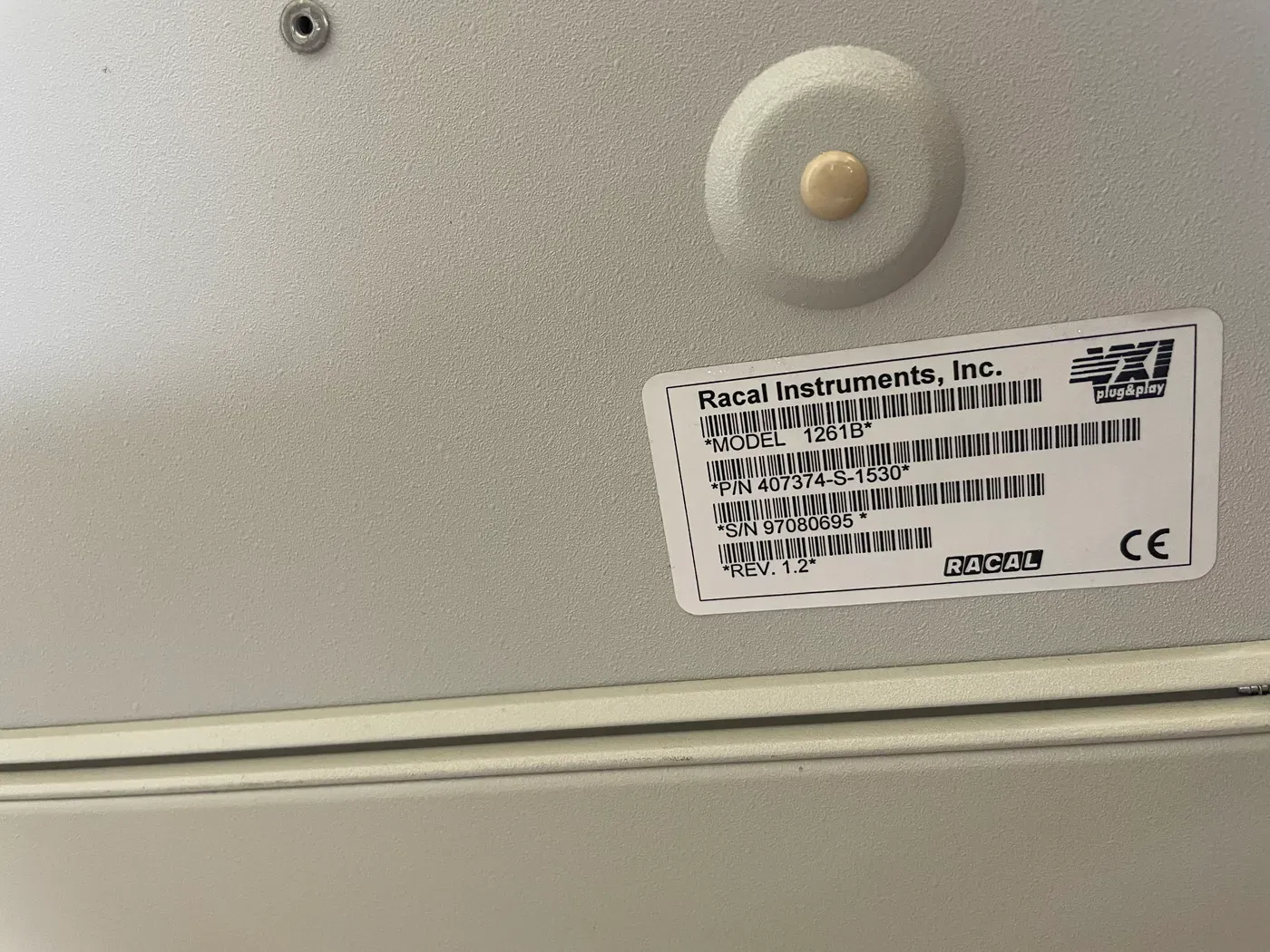 Racal Instruments identification label on a 1261B VXI mainframe showing model 1261B, part number 407374-S-1530, serial number 97080695, revision 1.2, with VXI plug and play and CE marks