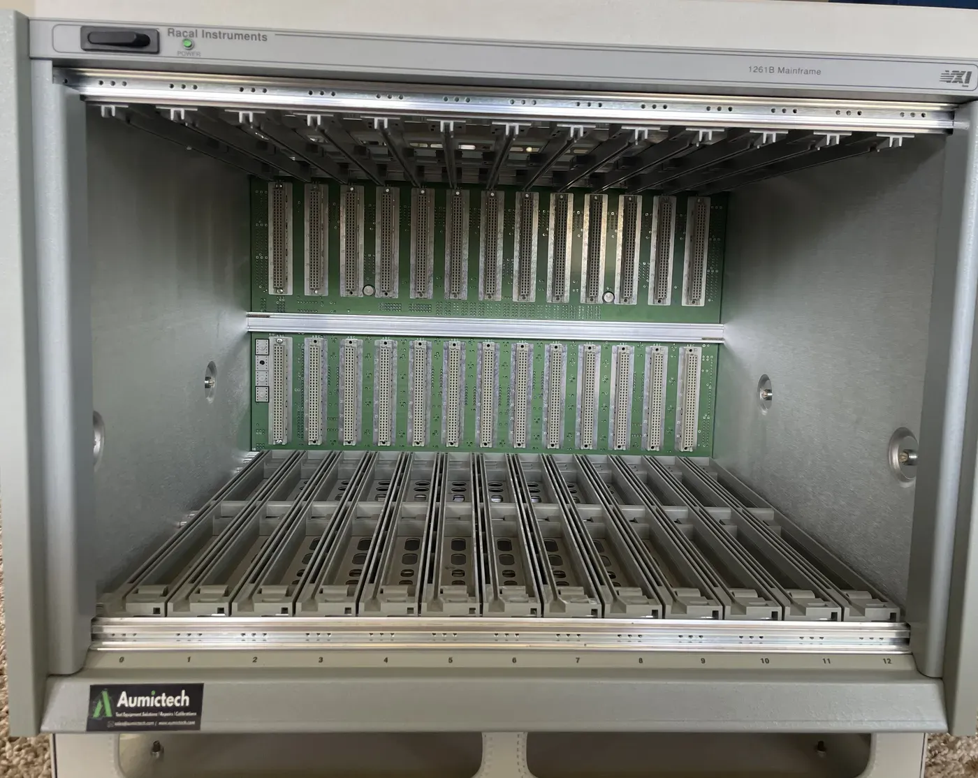 Racal Instruments 1261B VXI mainframe front view with the card cage empty, showing all 13 C-size slots, the two rows of backplane connectors, and the molded card guides